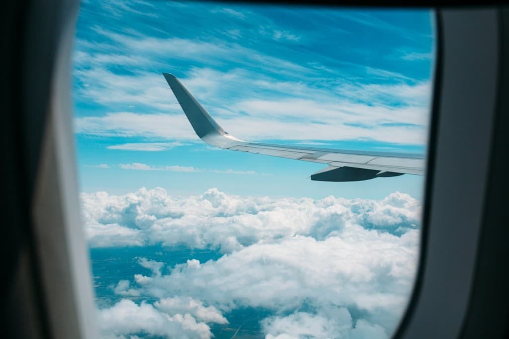 Uitzicht vanuit een vliegtuigraam boven de wolken